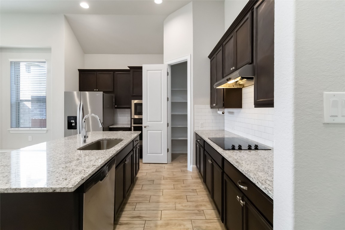 112 Barrel Bend Georgetown, TX 78628 - Photo 12 of 39 a kitchen with granite countertop counter space a sink stainless steel appliances and cabinets
