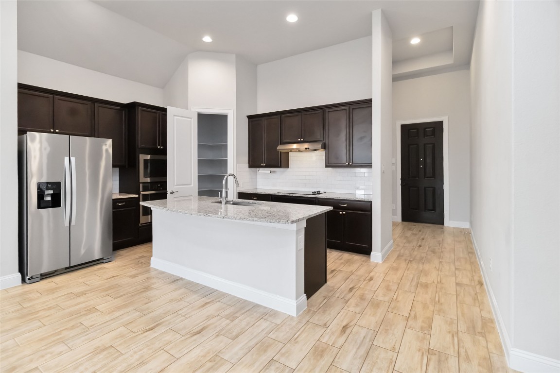 112 Barrel Bend Georgetown, TX 78628 - Photo 13 of 39 a large kitchen with stainless steel appliances kitchen island granite countertop a refrigerator oven a sink and dishwasher