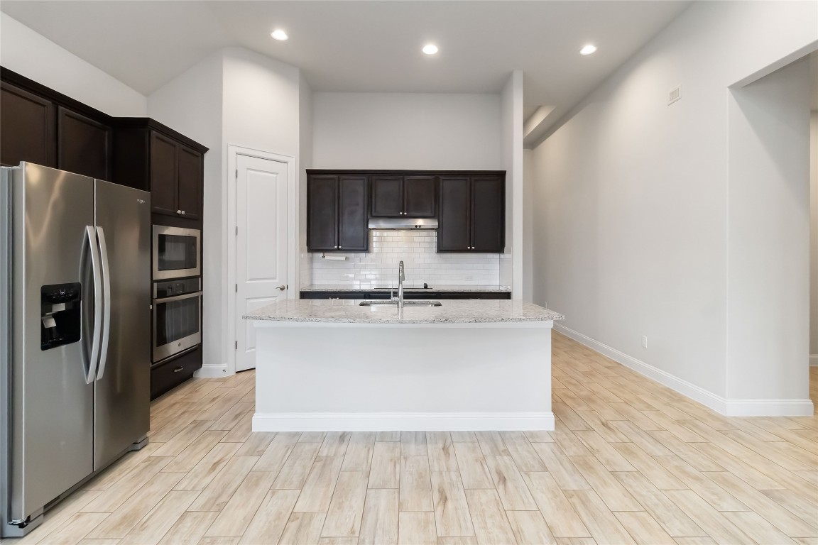 112 Barrel Bend Georgetown, TX 78628 - Photo 14 of 39 a large kitchen with stainless steel appliances a large counter top a refrigerator and a stove