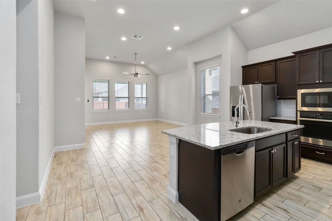 112 Barrel Bend Georgetown, TX 78628 - Photo 10 of 39 a kitchen with kitchen island granite countertop a sink stove and refrigerator
