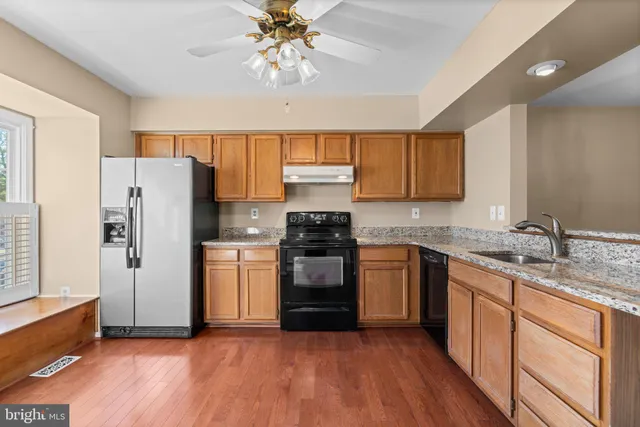 a kitchen with a refrigerator and a stove top oven