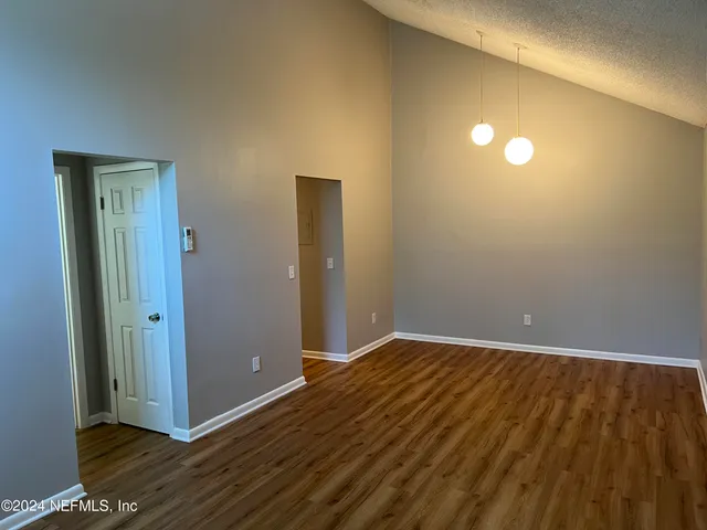 a view of an empty room with wooden floor