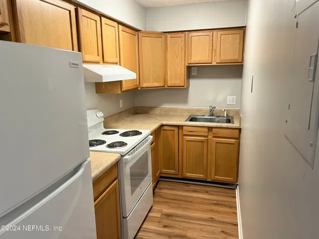 a kitchen with a stove top oven sink and cabinets