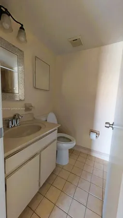 a bathroom with a granite countertop sink a toilet and a mirror
