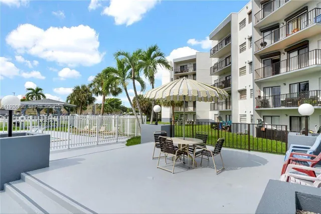 a view of a patio with couches table and chairs and potted plants