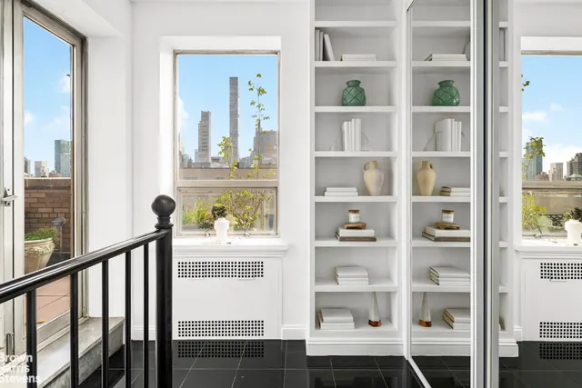 a living room with furniture kitchen view and a large window