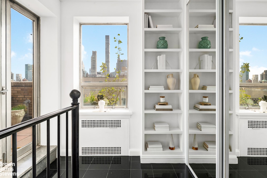 880 5th Avenue, Unit PHF Manhattan, NY 10021 - Photo 8 of 16 a view of a city from a balcony with a bench