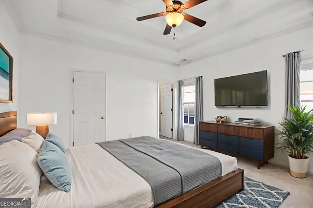 an empty room with chandelier fan and windows