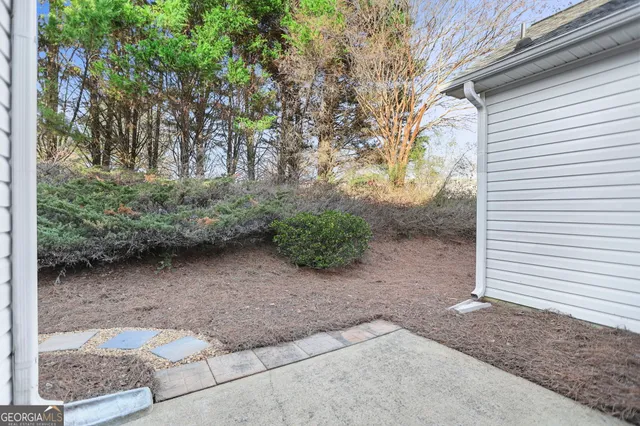 a view of a yard with plants and trees