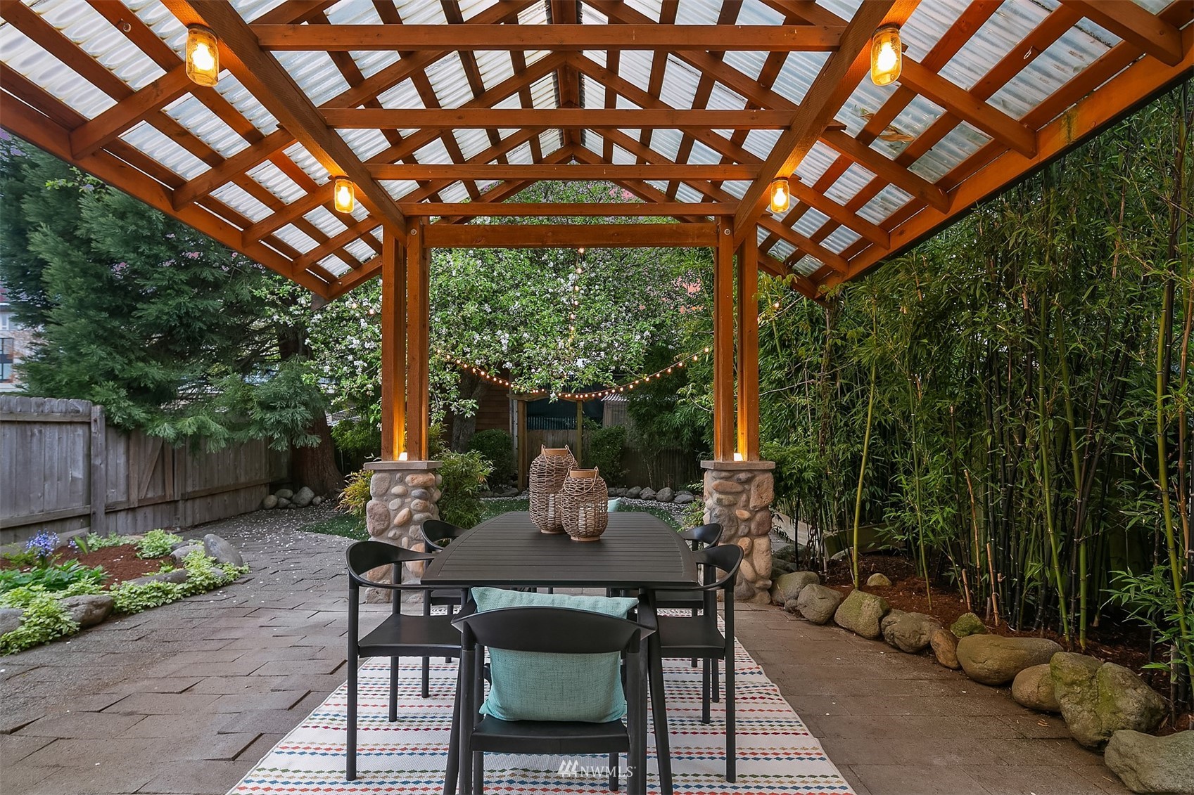 348 North 84th Street Seattle, WA 98103 - Photo 15 of 22 a view of a patio with table and chairs under an umbrella with a large tree