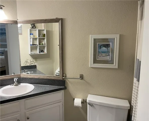 a bathroom with a toilet a sink and mirror