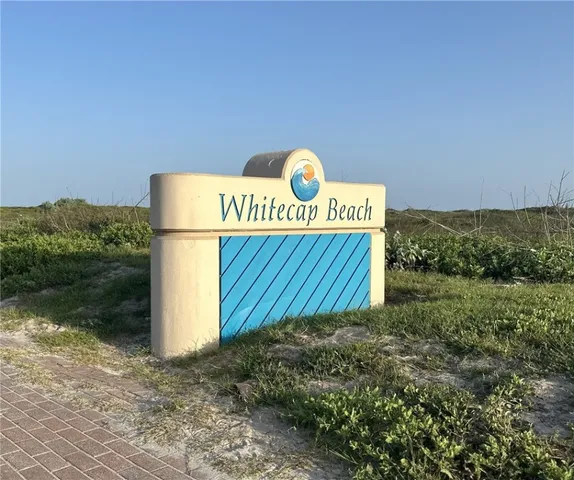 a view of a sign with barn in the background