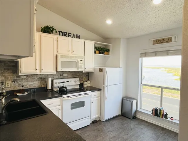 a kitchen with white cabinets and white appliances
