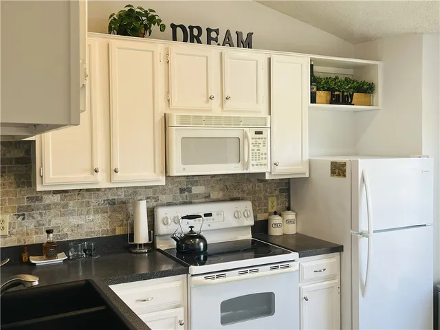 a kitchen with a white cabinets and white appliances
