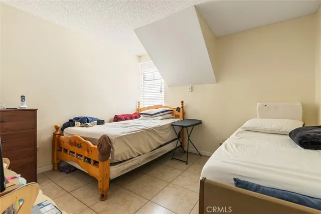a bedroom with a bed and a lamp on the dresser