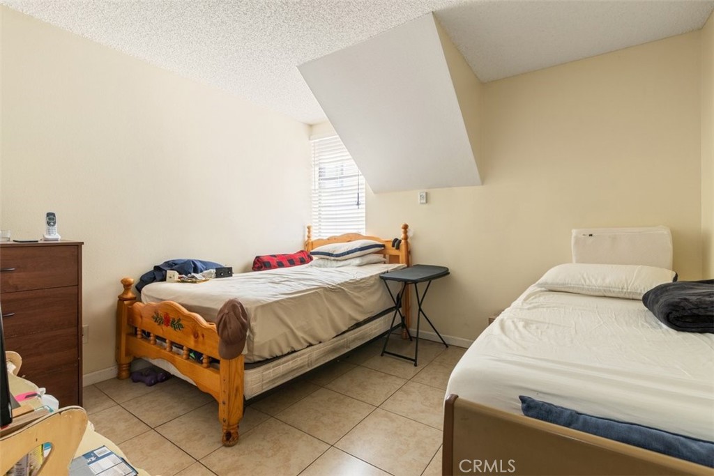 44544 15th Street East, Unit 9 Lancaster, CA 93535 - Photo 11 of 18 a bedroom with a bed and a lamp on the dresser