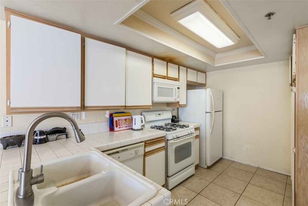 44544 15th Street East, Unit 9 Lancaster, CA 93535 - Photo 8 of 18 a kitchen with stainless steel appliances a sink a stove and a refrigerator