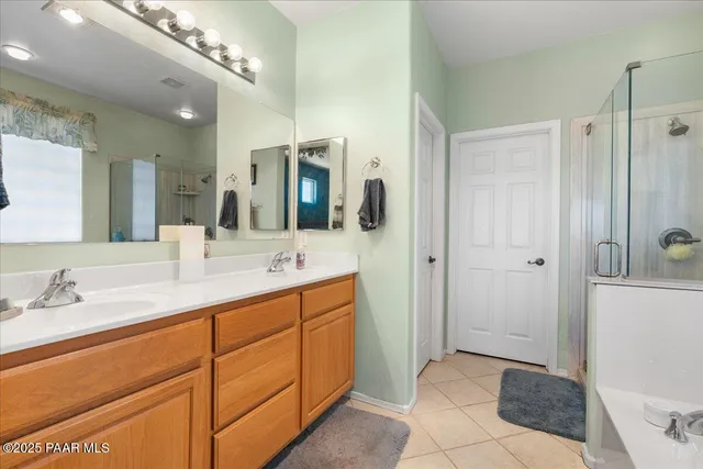 a spacious bathroom with a double vanity sink a mirror and shower
