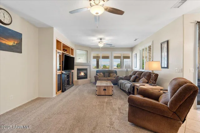 a living room with furniture a flat screen tv and a window