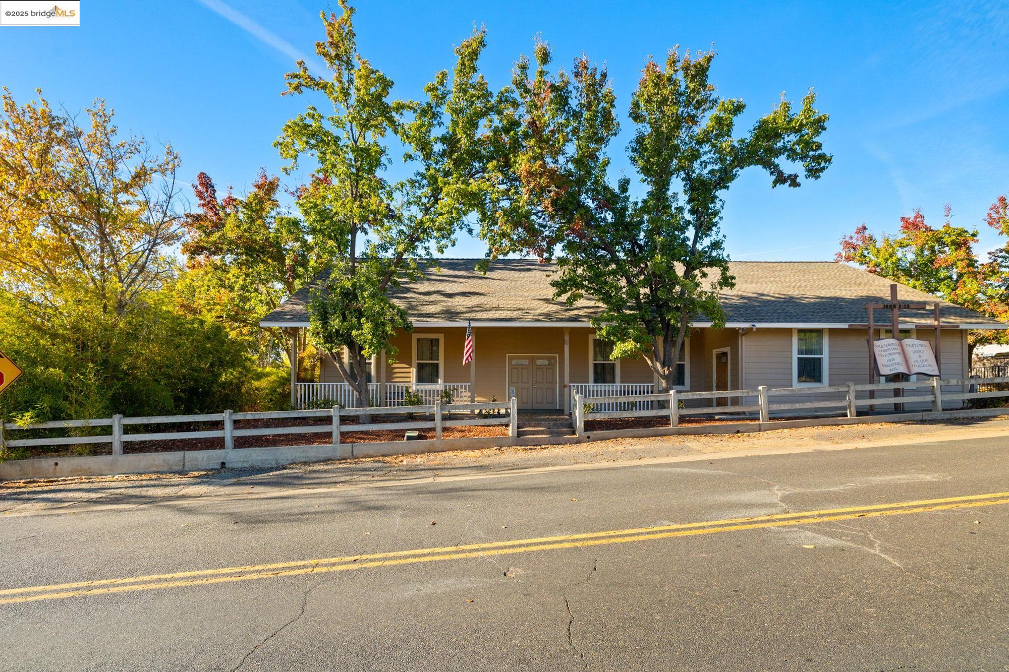 View of front of house featuring a fenced front yard, a porch, and roof with shingles
