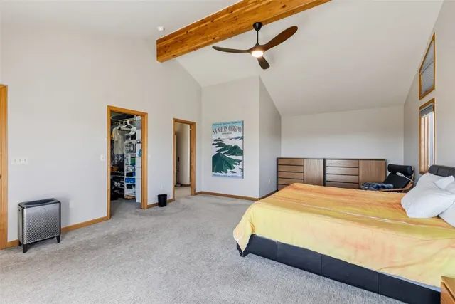 a bedroom with a bed and a lamp on the dresser