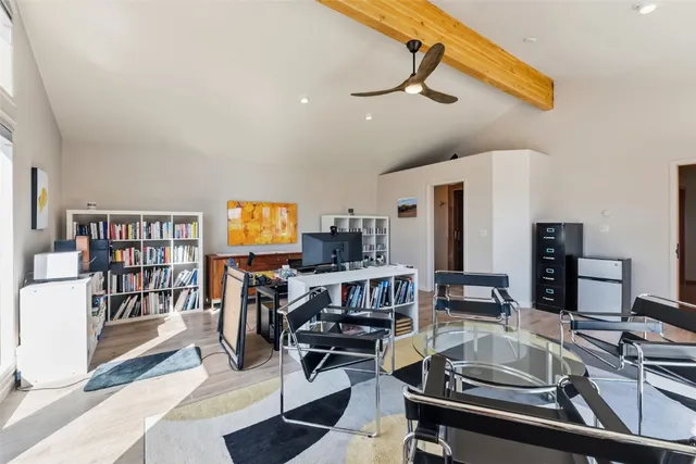 a kitchen with a sink appliances and a dining table with wooden floor