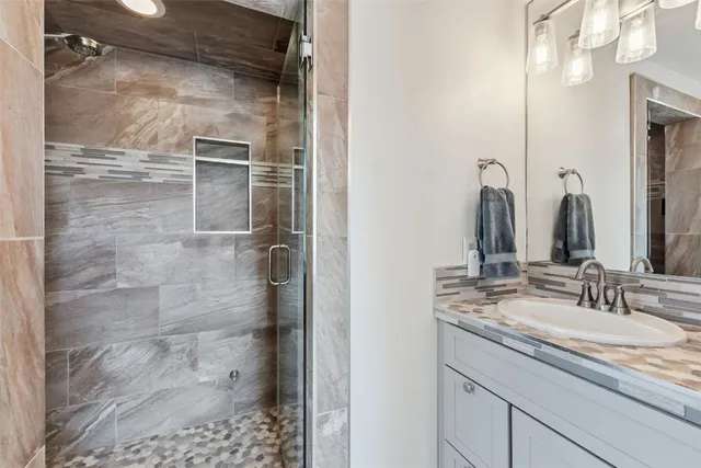 a bathroom with a shower sink and mirror