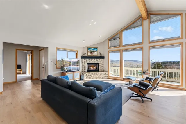 a living room with fireplace furniture and a large window