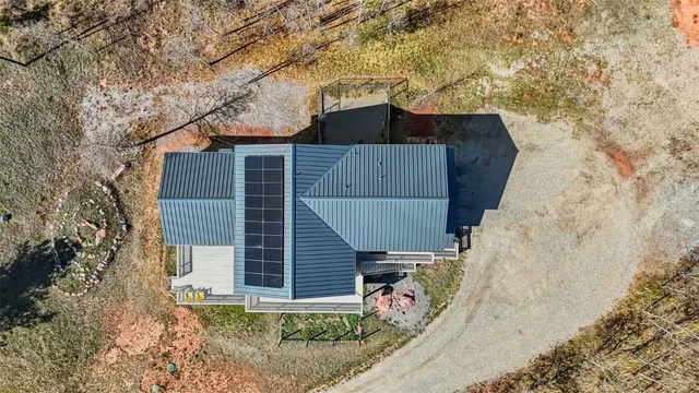 a view of a small house with a wooden fence
