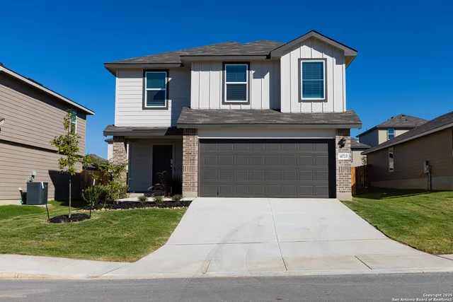 a front view of a house with a yard and garage