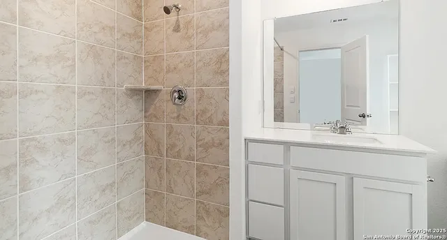 a bathroom with a shower sink and mirror