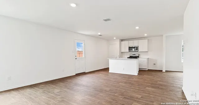a view of kitchen with wooden floor and electronic appliances