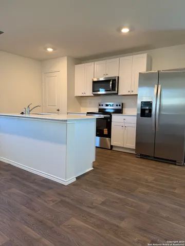 a kitchen with stainless steel appliances a refrigerator and a stove top oven
