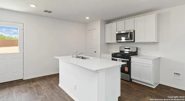 a kitchen with stainless steel appliances a sink a stove and microwave