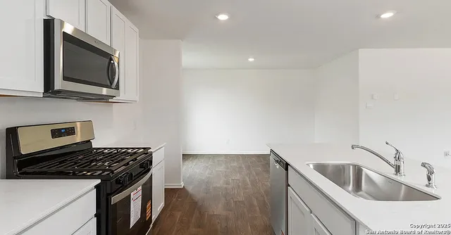 a kitchen with a sink stove and microwave