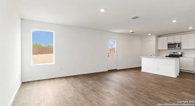 a view of kitchen with wooden floor and electronic appliances