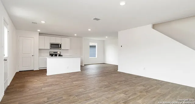 a view of kitchen with granite countertop cabinets and refrigerator