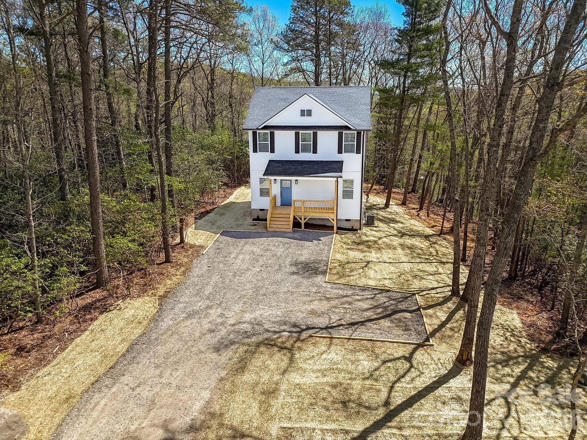 99 Lee Dotson Road Fairview, NC 28730 - Photo 2 of 47 a front view of a house with a yard covered with trees