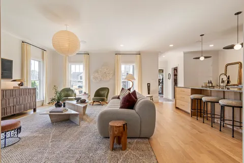 a living room with furniture flat screen tv and a large window