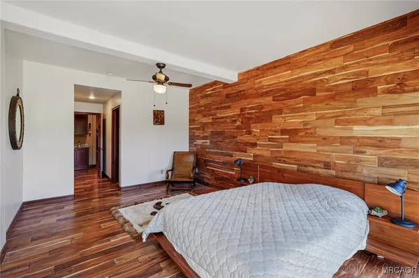 a bedroom with a bed and wooden floor