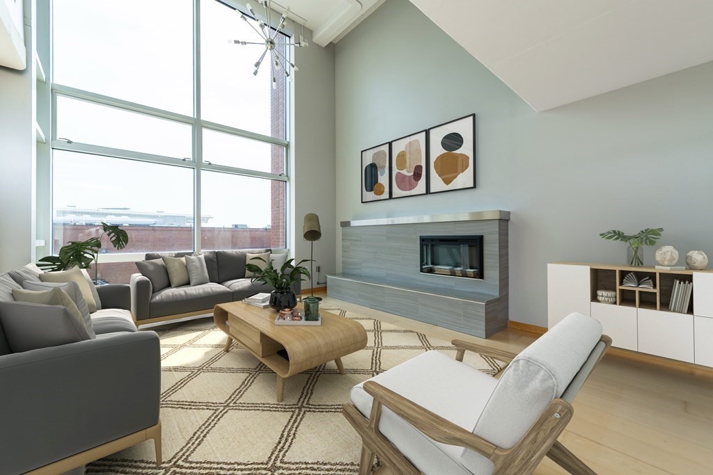 25 Channel Center Street, Unit 202 Boston, MA 02210 - Photo 1 of 18 a living room with furniture a fireplace and a floor to ceiling window