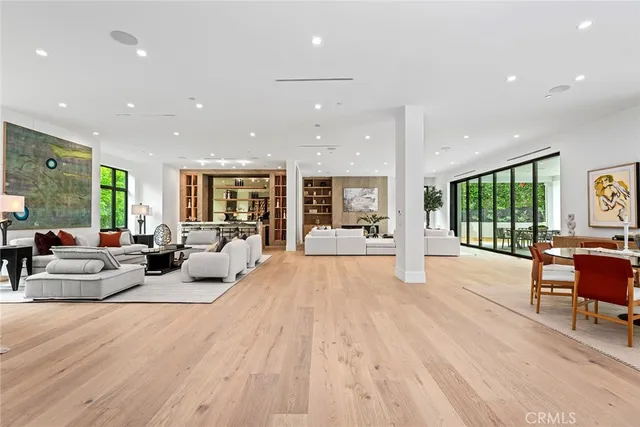 a living room with furniture wooden floor and a large window