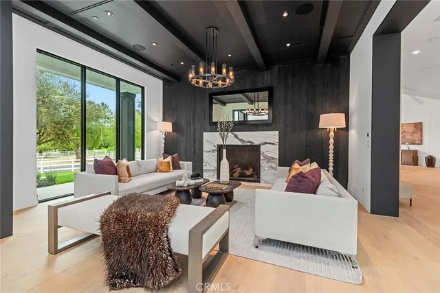 a living room with furniture a fireplace and a large window