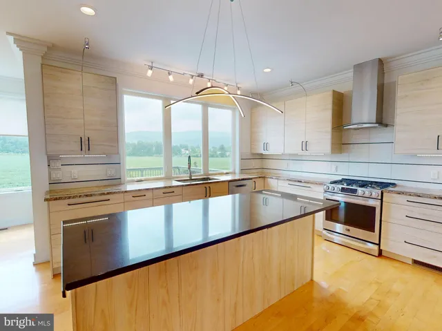 a kitchen with stainless steel appliances granite countertop a sink a stove and a refrigerator