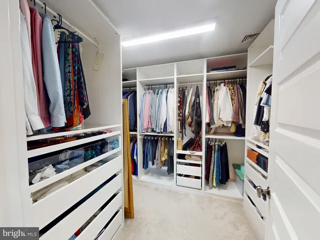 a view of walk in closet with clothes and shoes
