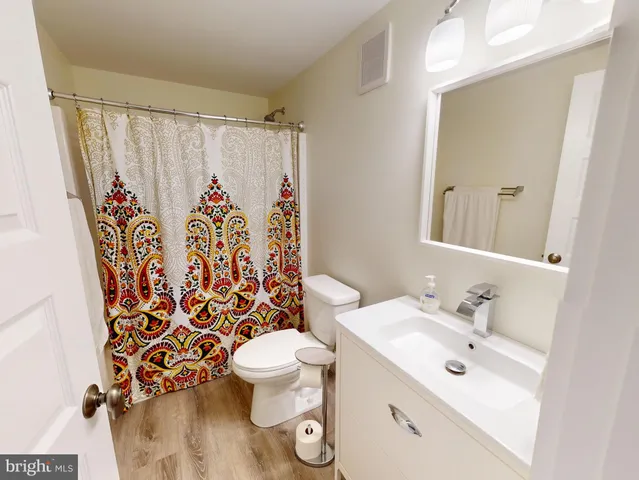 a living room with furniture and a flat screen tv with wooden floor