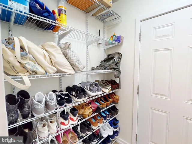 a view of walk in closet with clothes and shoes