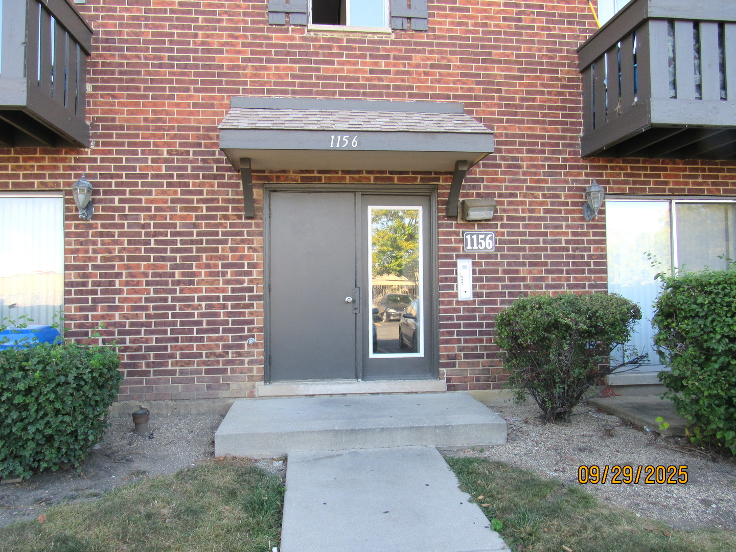 a view of a brick house with potted plants