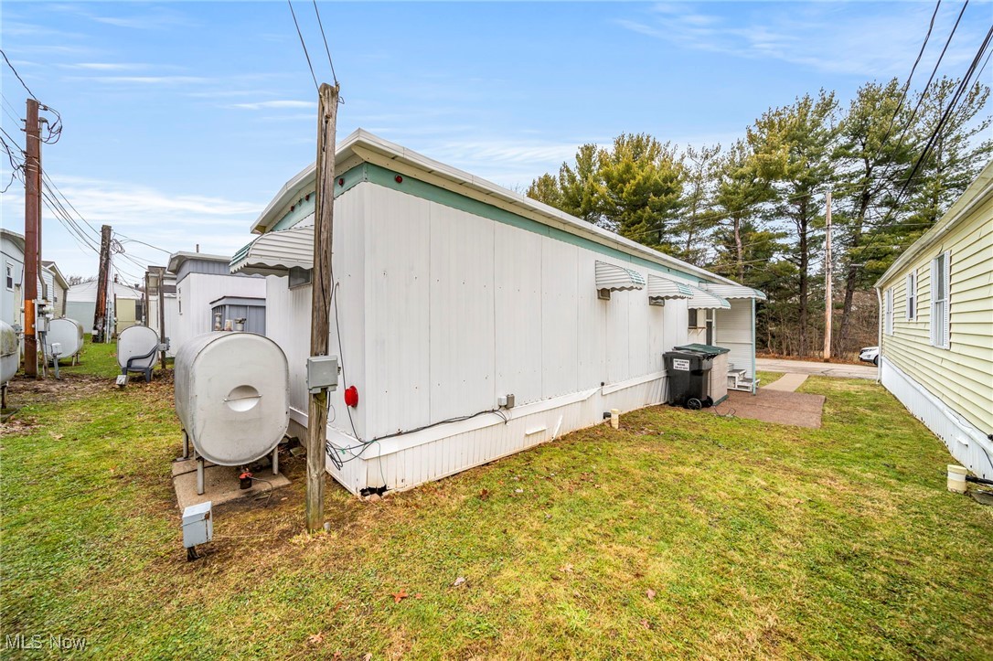 9735 Chillicothe Road, Unit 30 Kirtland, OH 44094 - Photo 5 of 10 View of home's exterior with a lawn and heating fuel