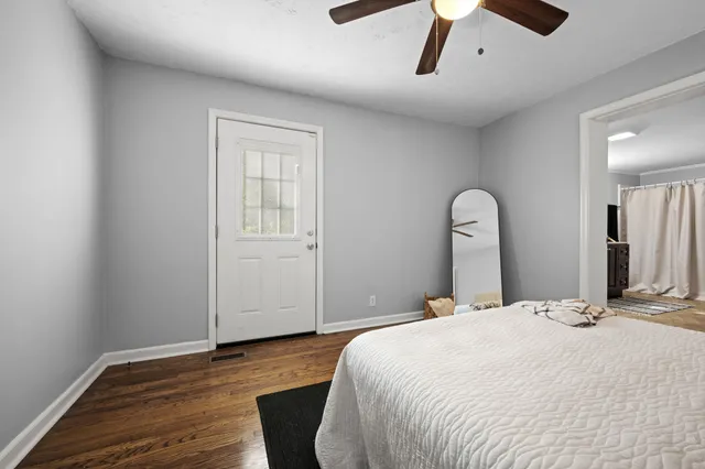 a bedroom with a bed and wooden floor